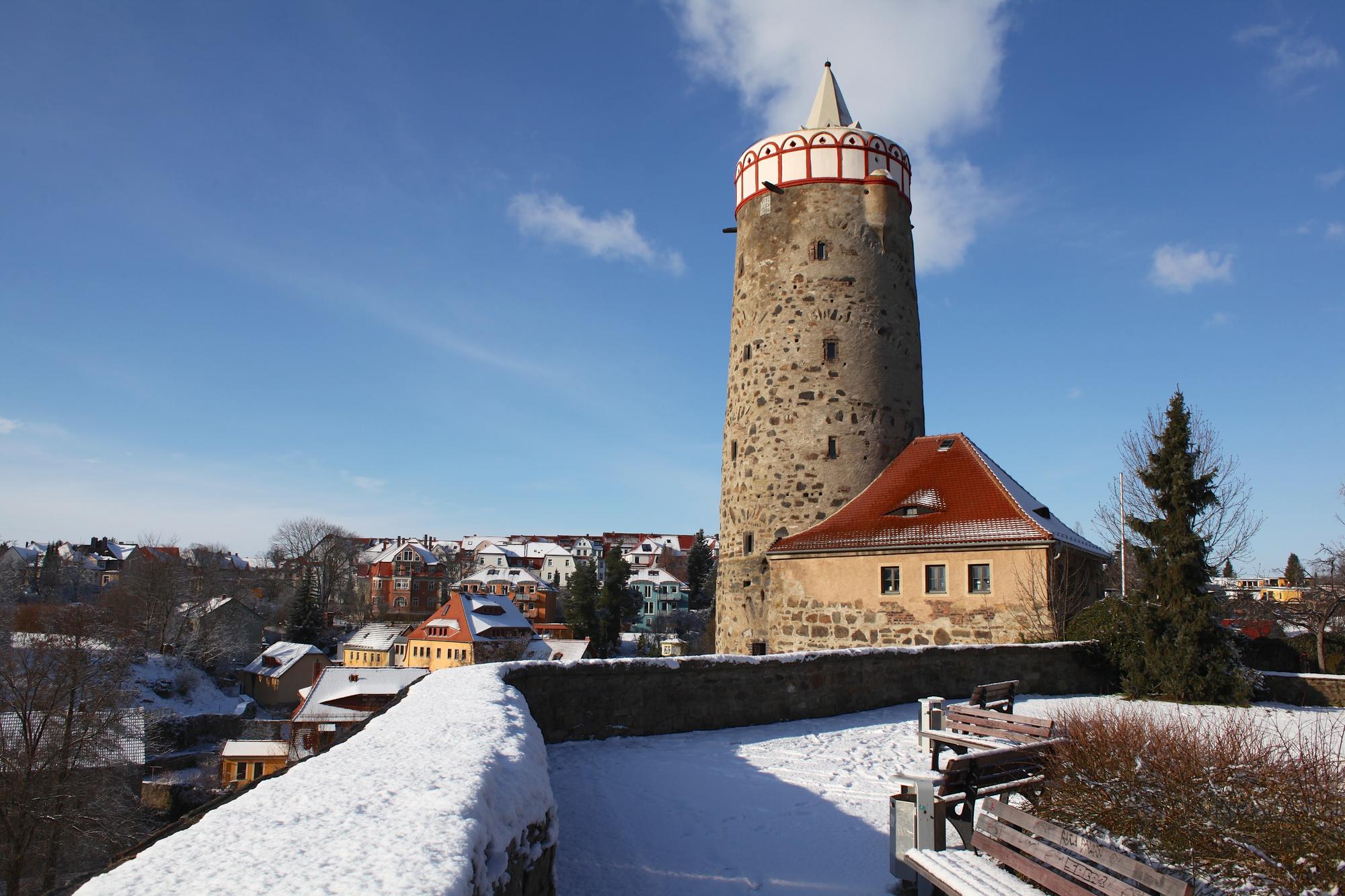 Alte Wasserkunst in Bautzen, dovor eine schneebedeckte Mauer und Parkbänke